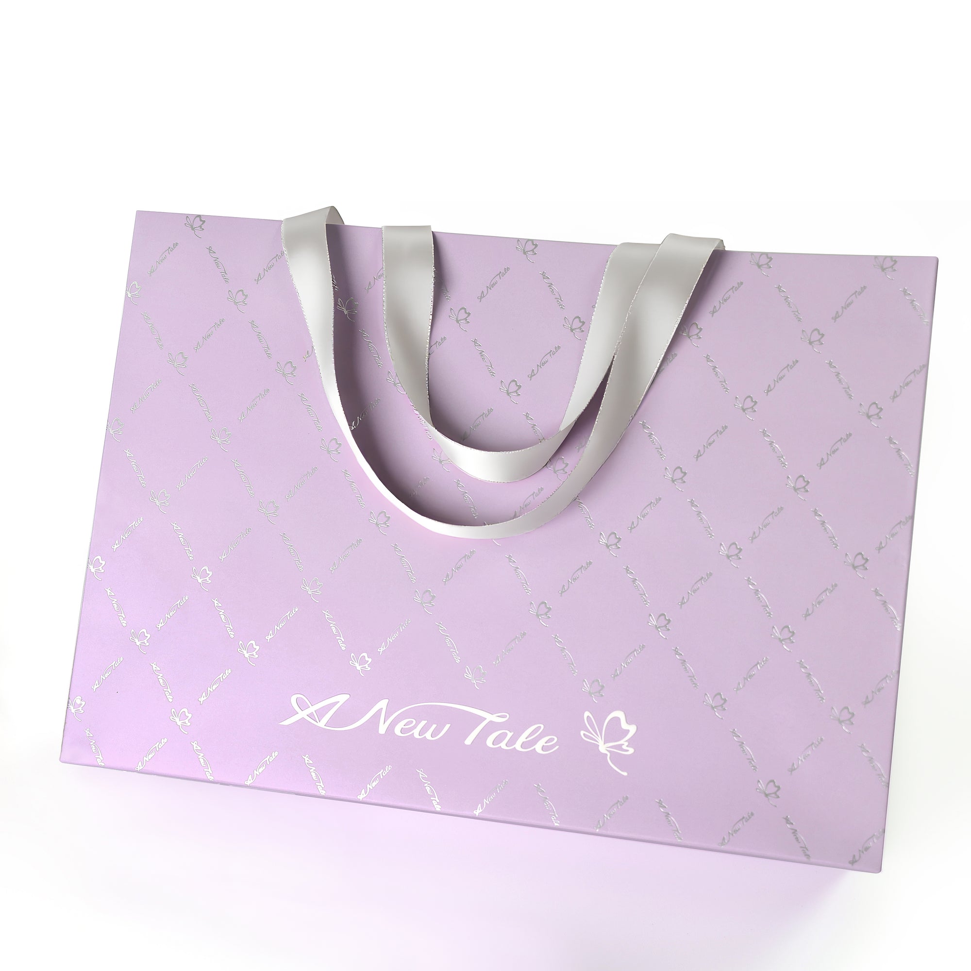 Purple paper bag with silver handles and 'A New Tale' text on a white background