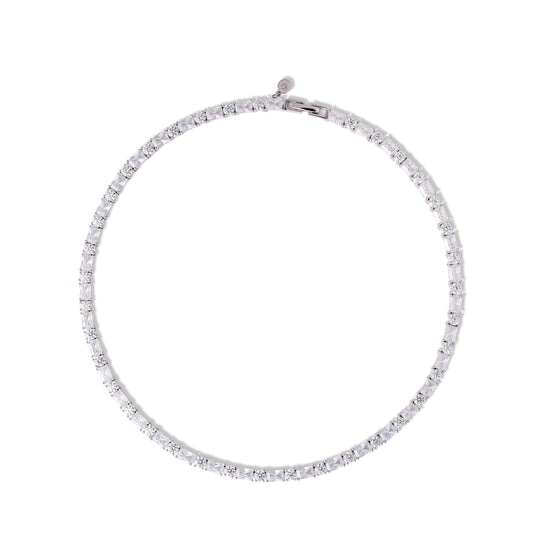 A Silver Tennis Necklace is designed in an alternating sequence of princess-cut and round-cut stones — a subtle rhythm that catches the light differently from every angle on a white background.